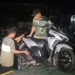 Salah satu pemuda yang terjaring razia balap liar sedang memasang spare part motornya agar menjadi standar pabrikan.