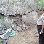 Kapolsek Sawoo bersama Kades Pangkal saat meninjau keretakan tanggul penahan jalan.