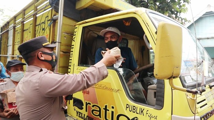 Macet Berjam-jam, Polres Gresik Bagikan Nasi Bungkus dan Air Mineral ke Sopir Truk di Jalur Pantura