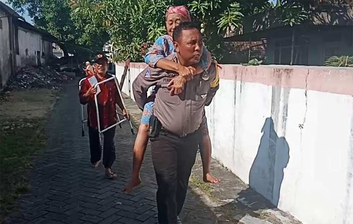 Coblosan Pilgub Jatim, Polisi di Lamongan Gendong Nenek Stroke ke TPS