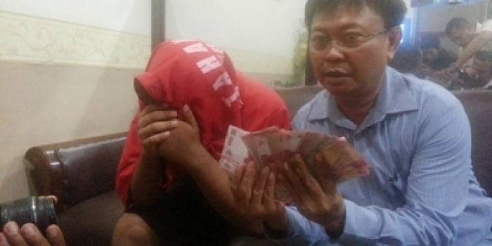 ?Tersangka didampingi petugas beserta barang bukti uang hasil penjualan. Foto:rusmiyanto/BANGSAONLINE