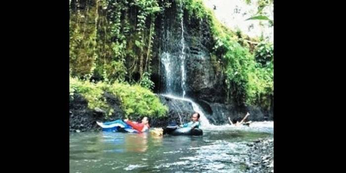 Baidhawi bersama pengunjung saat melakukan tubing (ngintir) dengan ban mobil. Foto: Sugiyanto/BangsaOnline.com