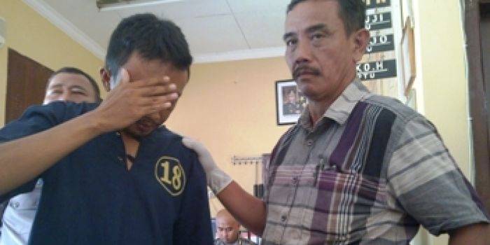 Herman saat digelandang ke Polsek Kenjeran. foto: rusmiyanto/BANGSAONLINE